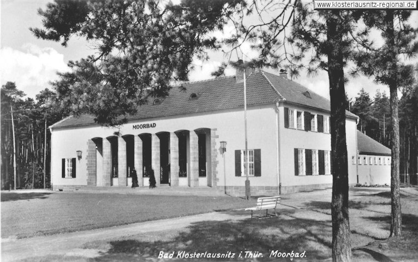 Das historische Gebäude des Moorbads steht umgeben von Bäumen in einer ruhigen Landschaft in Bad Klosterlausnitz.