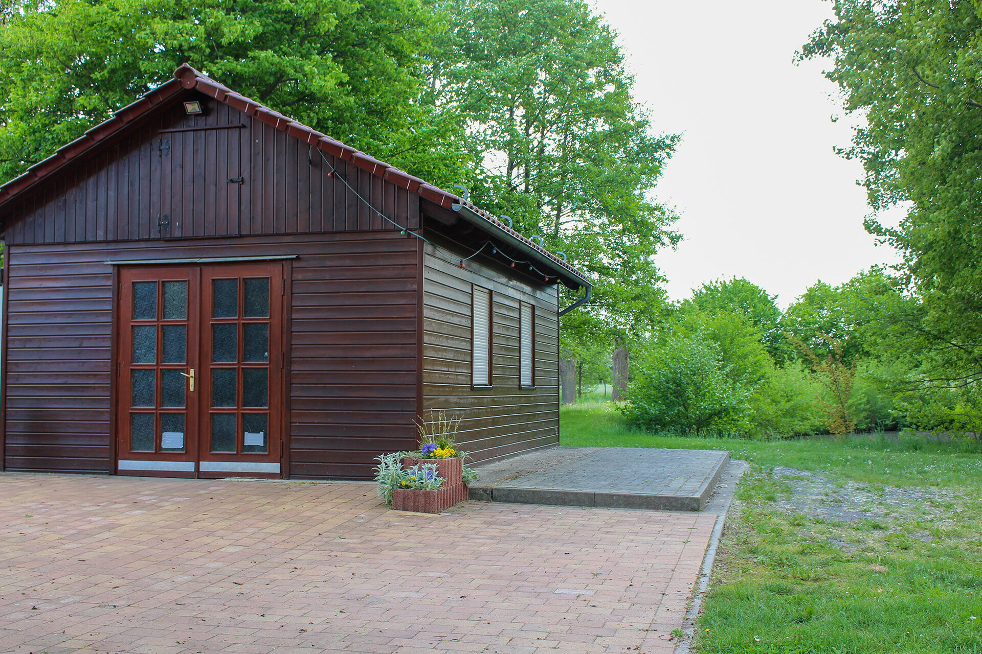 Ein gemütliches Vereinshaus des Heimatvereins Klengel e.V. steht umgeben von grünen Bäumen und gepflegtem Rasen.