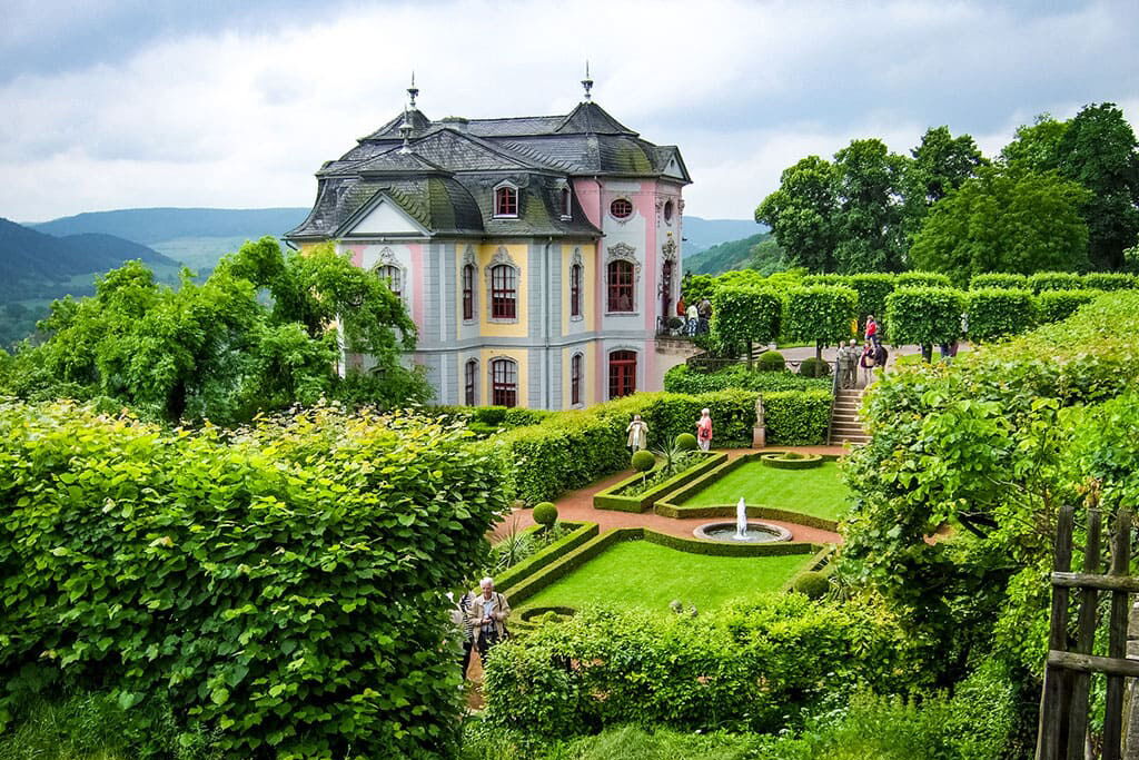 Das Dornburger Schloss thront über gepflegten Gärten, umgeben von üppigem Grün und erkundet von Besuchern.