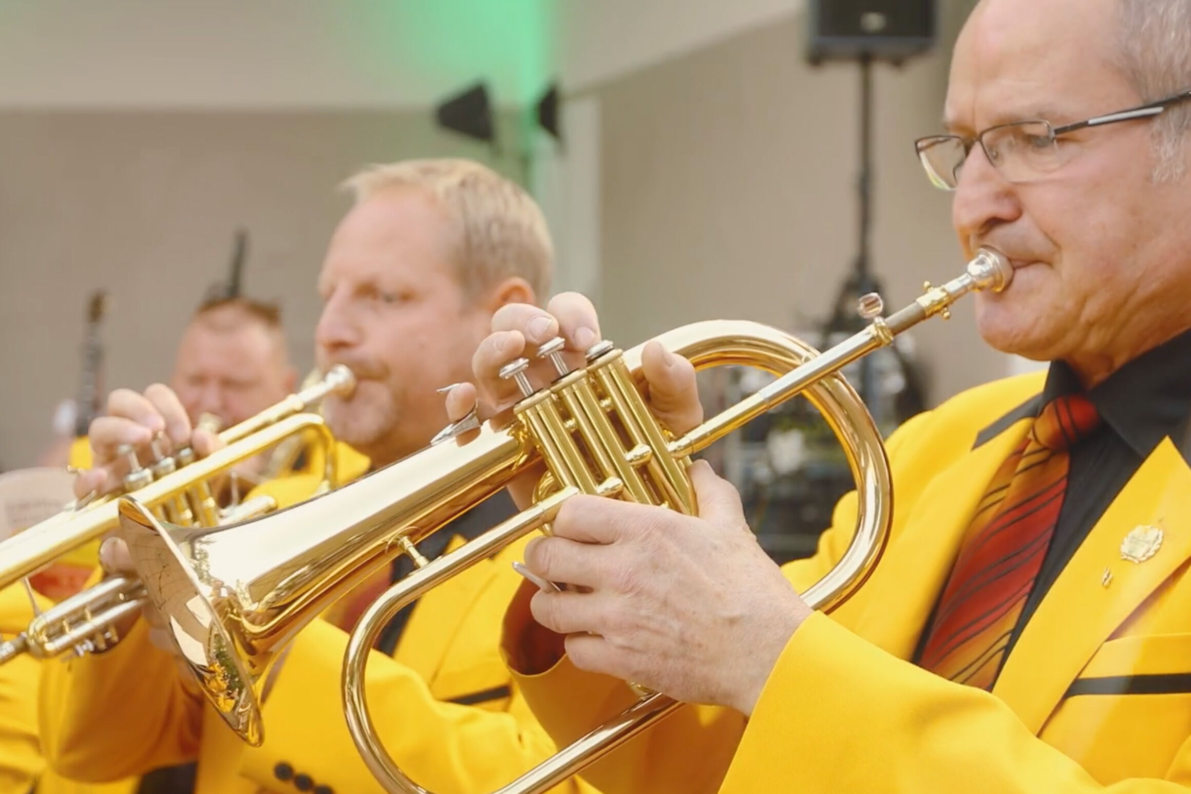 Musiker in gelben Uniformen spielen Trompeten bei einem Konzert im Kurpark von Bad Klosterlausnitz