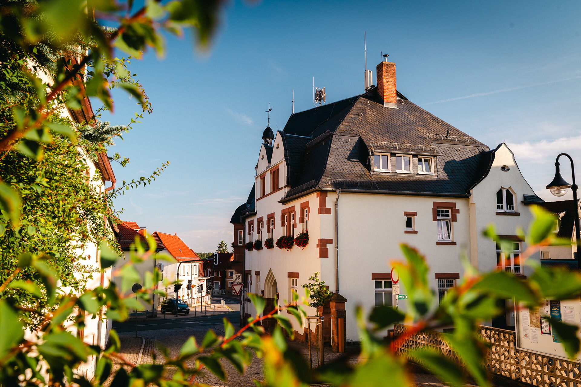 Das charmante, historische Rathaus mit roten Ziegeln steht im sonnigen Ortszentrum von Bad Klosterlausnitz, Symbolbild für Ortsrecht