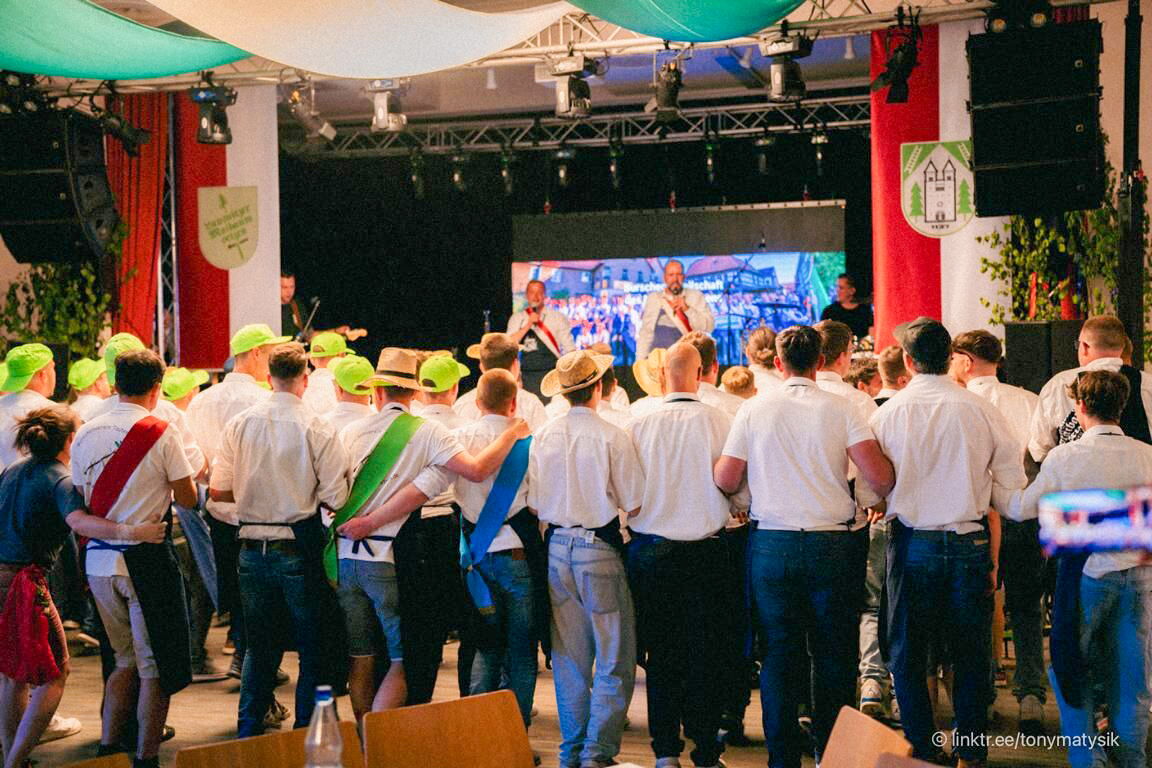 Maibaumsetzter in festlicher Kleidung und bunten Hüten feiern zusammen Holzlandsaal Bad Klosterlausnitz